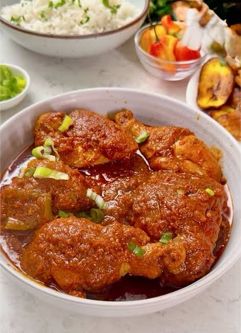 African chicken stew served with white rice and sweet fried plantains