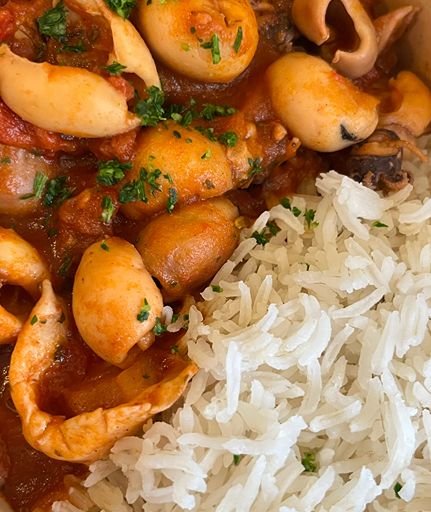 African chicken stew served with rice and fried plantains